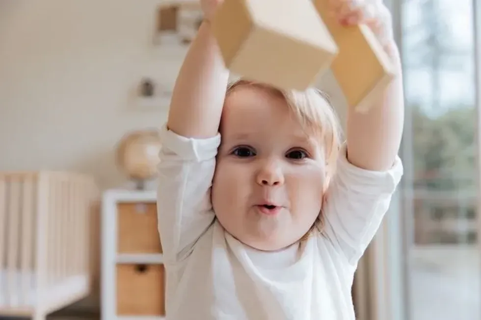 A baby boy playing with his wooden toy