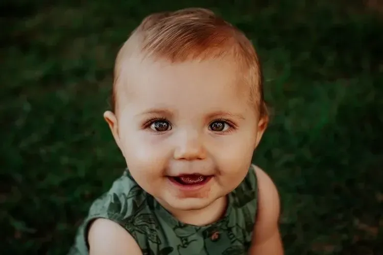 A baby boy smiling at the camera