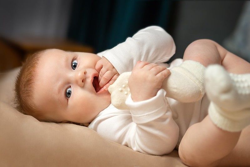 A baby is lying on the bed.