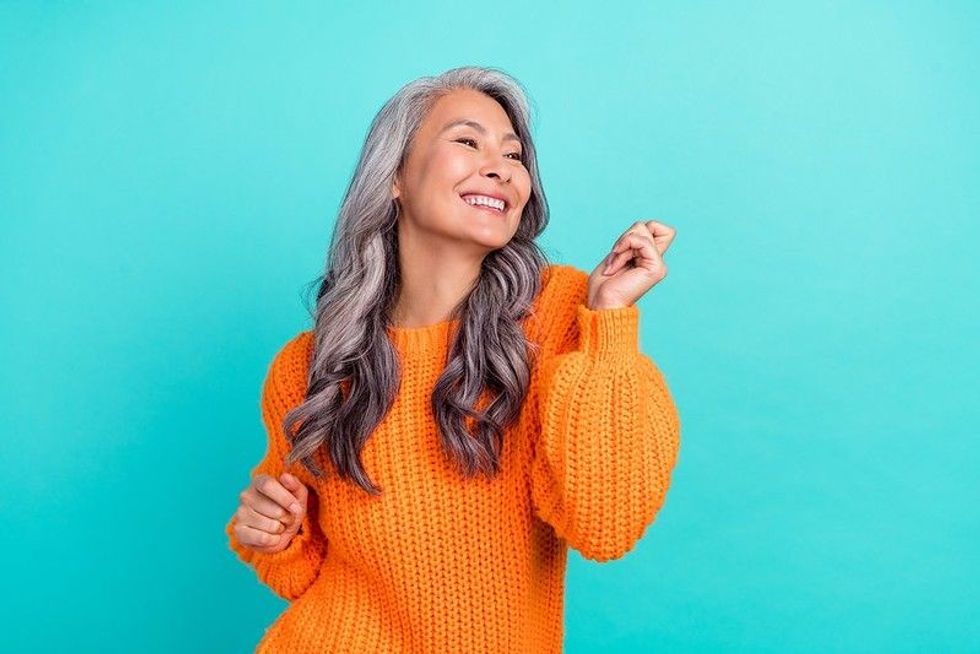 A lady in orange smiling.