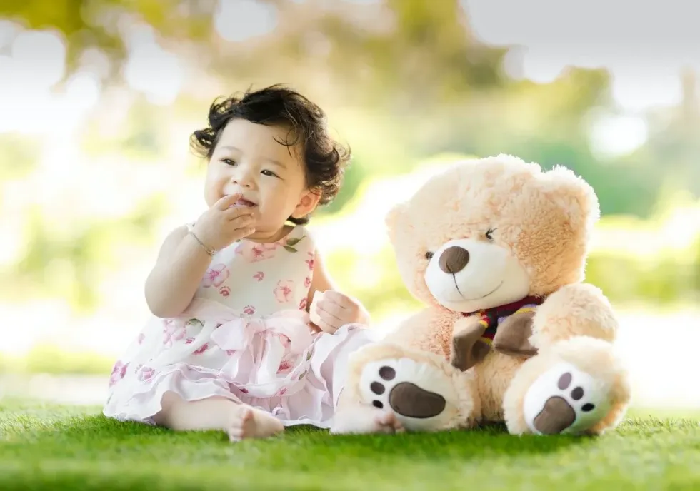 A little baby girl playing with her teddy bear