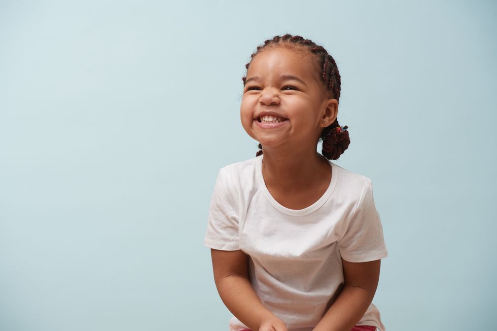 A little girl with braids smiling.