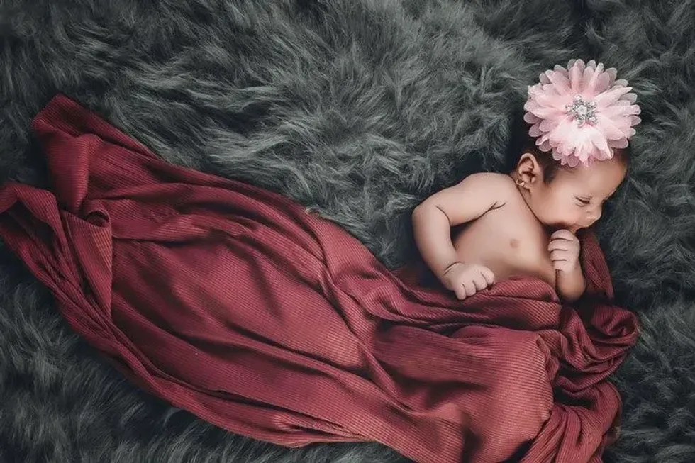 A newborn baby girl sleeping on fur