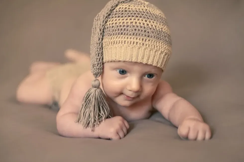 A newborn baby wearing brown knitted cap