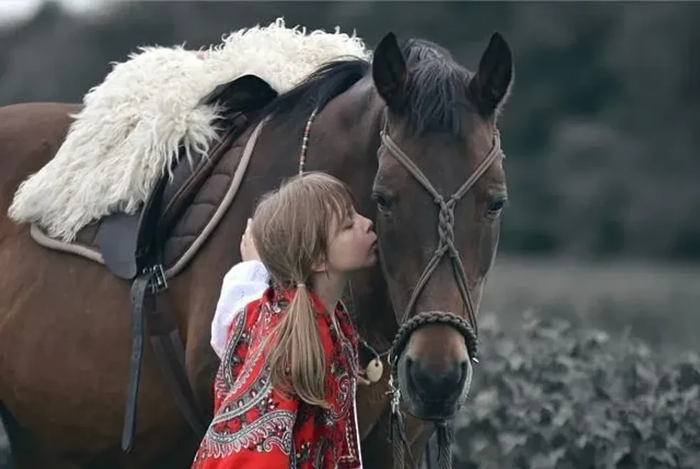 A Slavic girl with her brown horse