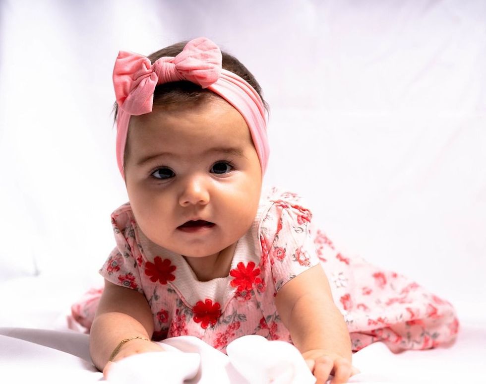 A Spanish kid with pink dress and headband