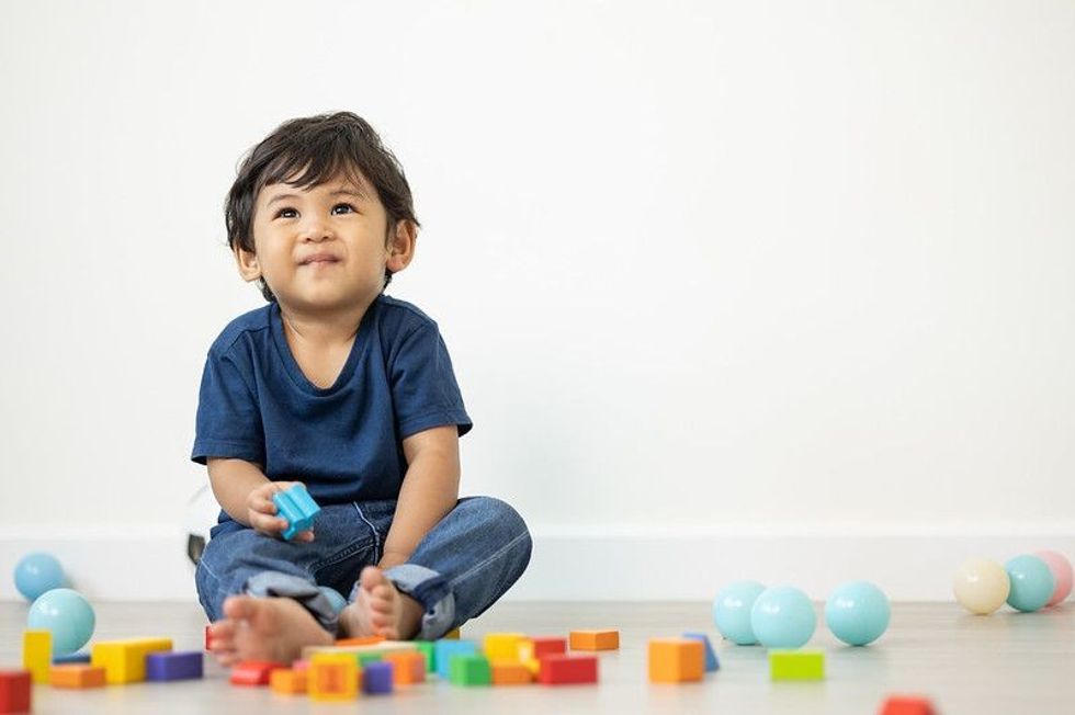 An Asian boy about 1 year old Playing in the living room.