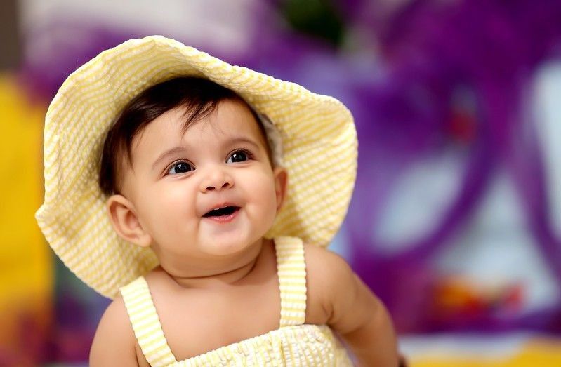 Baby girl wearing yellow hat and dress