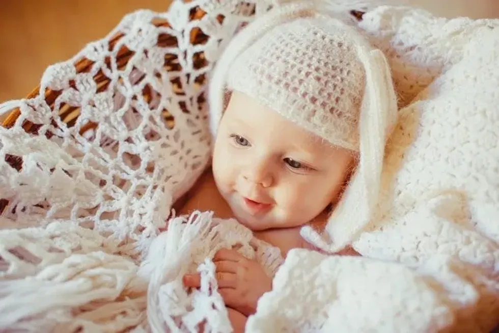 Baby in a white knitted basket