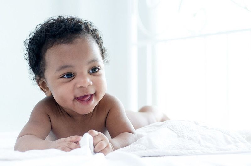 Curly haired newborn baby smiling