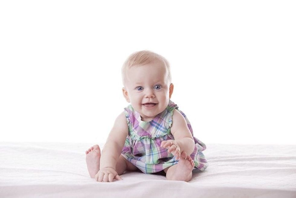 Cute baby girl smiling on bed.