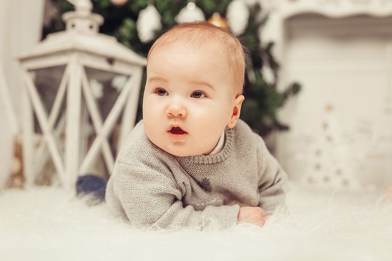 Cute baby sitting on fluffy couch