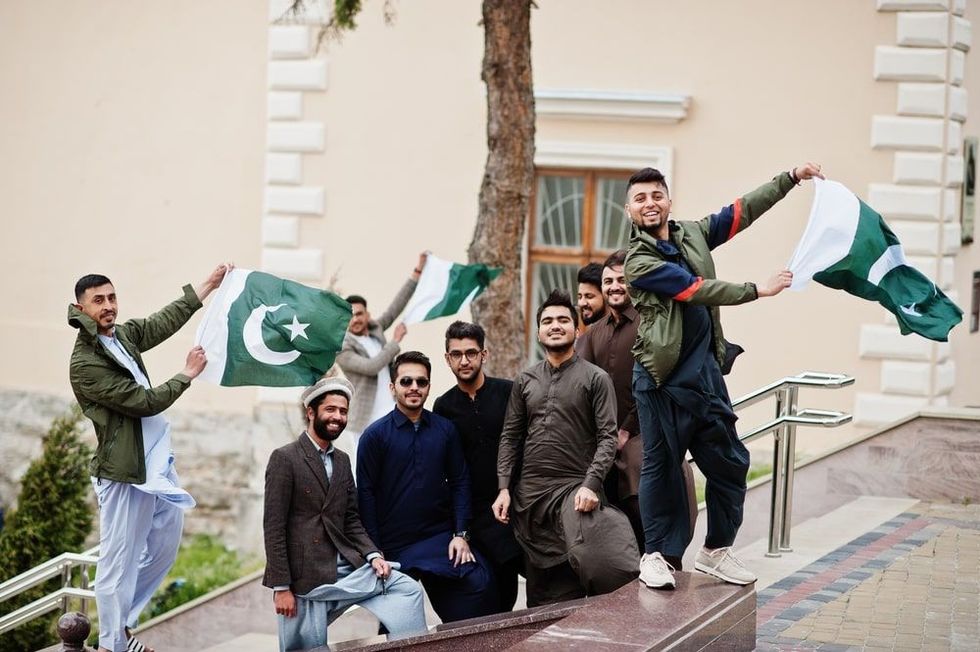 Group of pakistani man wearing traditional clothes salwar kameez or kurta with Pakistan flags