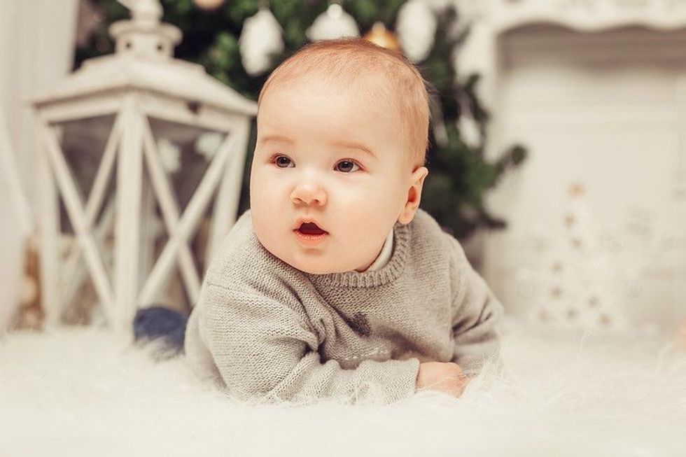 Happy baby boy lying down and having a good time at home