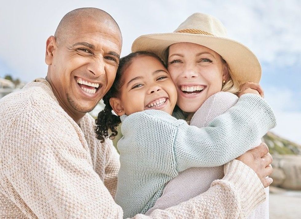 Happy little girl and her parents on picnic