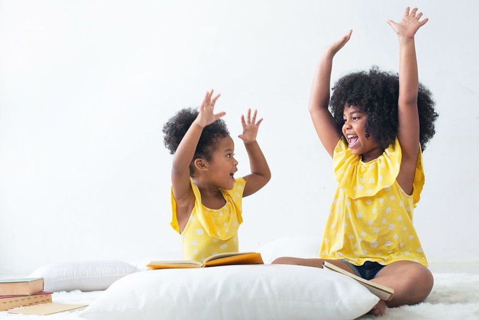 Happy sisters in same yellow dress.