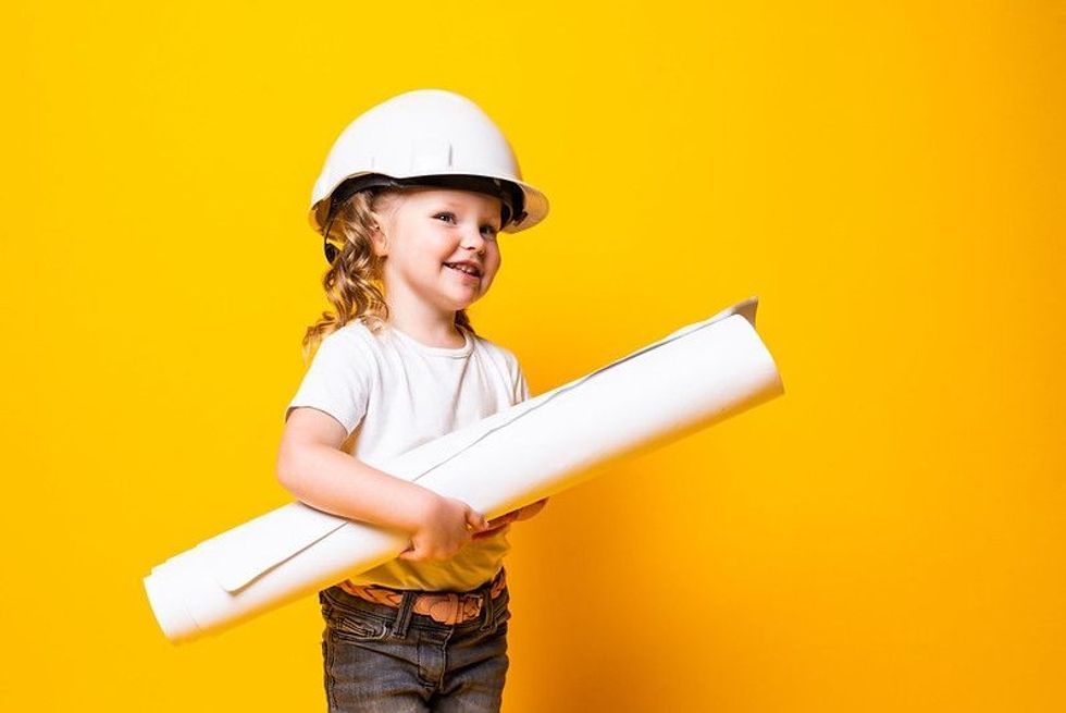 Happy young girl engineer with helmet