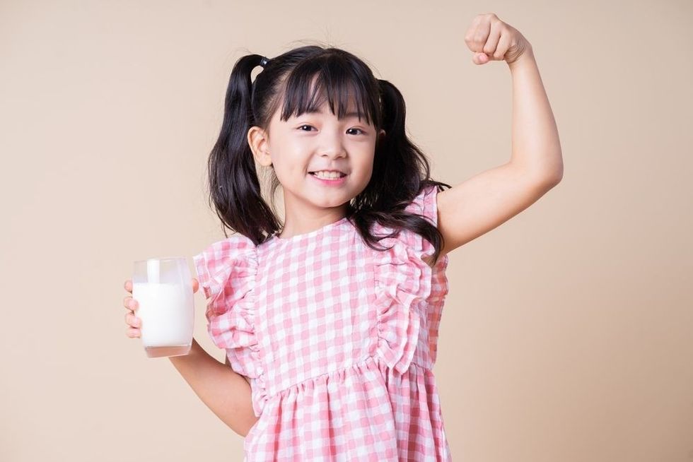 https://www.shutterstock.com/image-photo/image-asian-child-drinking-milk-on-2148772093tAsian girl wearing pink top holding cup of milk