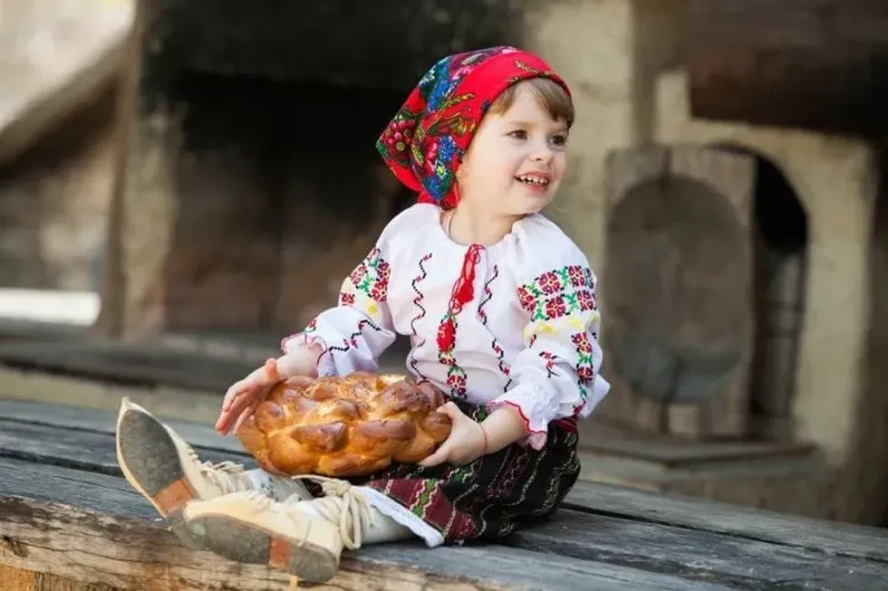 Little girl in traditional Romanian folk costume with embroidery.