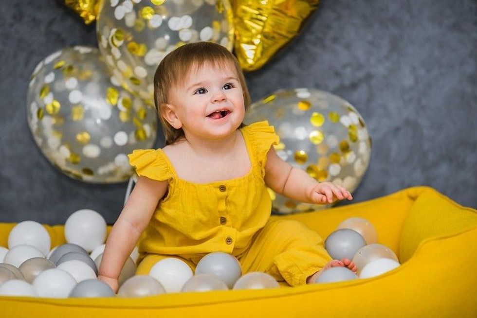 Little girl playing in birthday balls