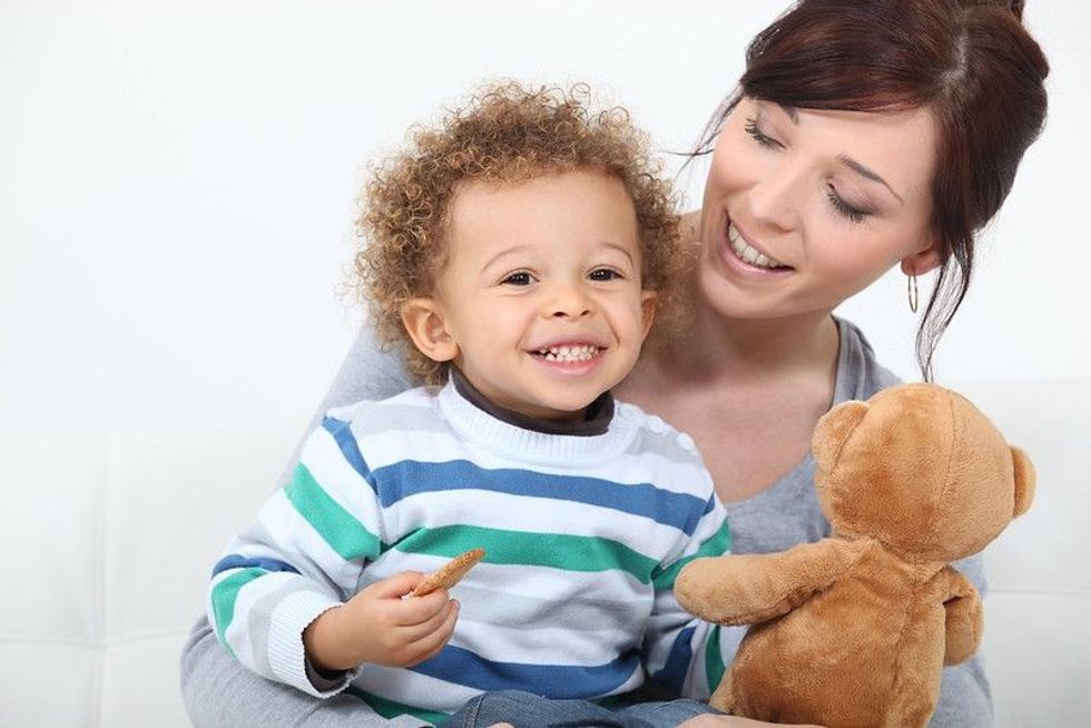 Mother and baby playing with teddy bear toy