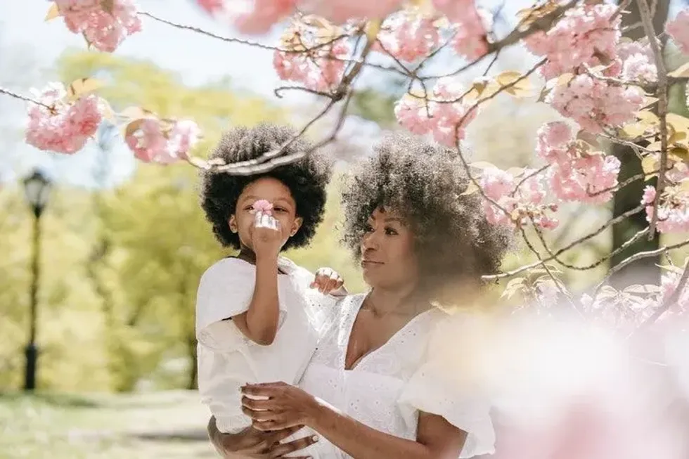 Mother and daughter under a pink flower tree