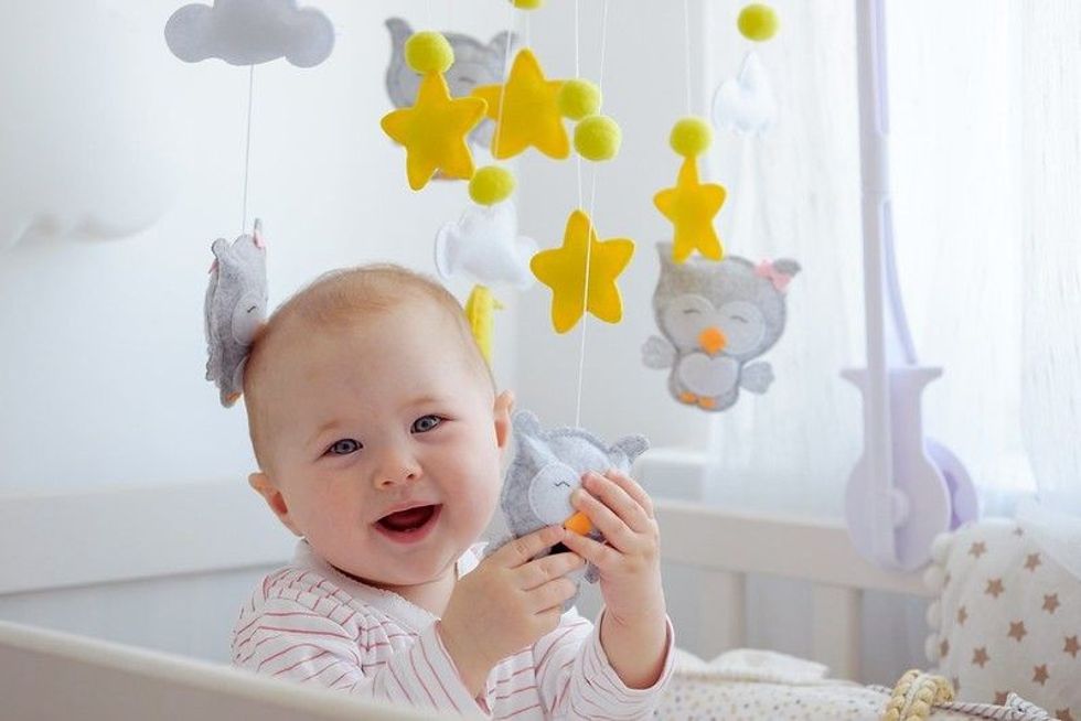 Newborn baby playing with stars and clouds