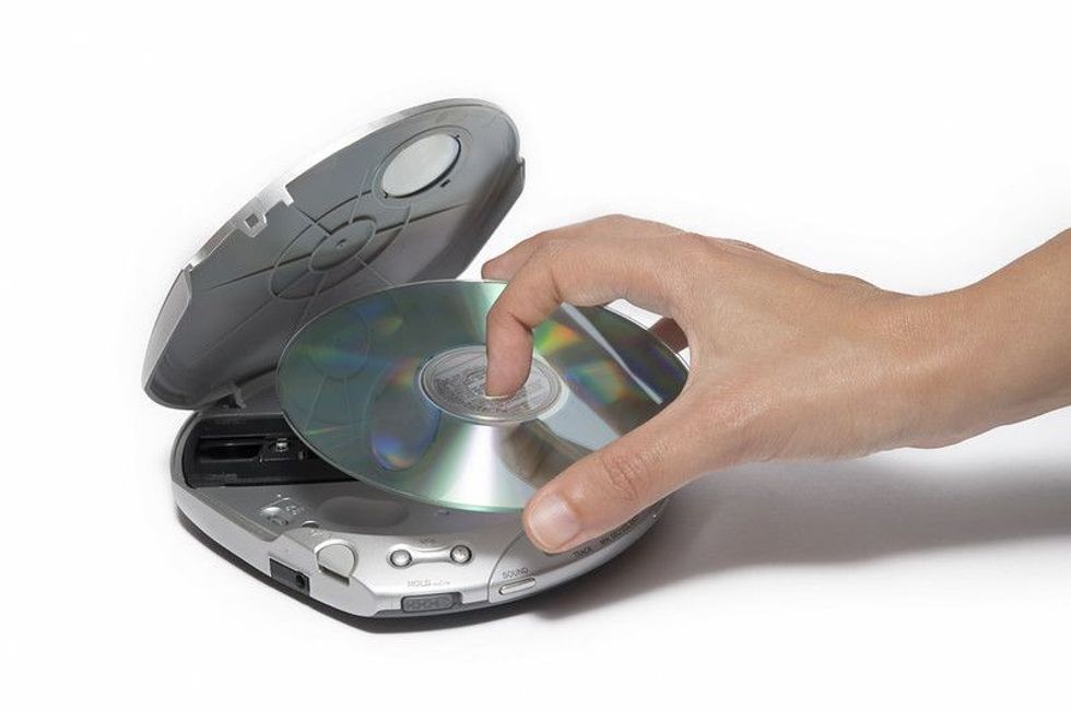 Person placing CD Inside Portable Cd Player.