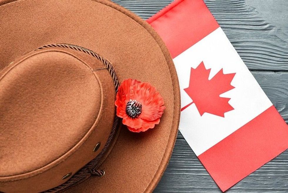 Poppy flower with hat and flag of Canada representing Day of Remembrance observed on Black ribbon Day