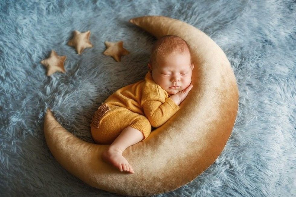 Studio portrait of a newborn baby boy wearing yellow pajama