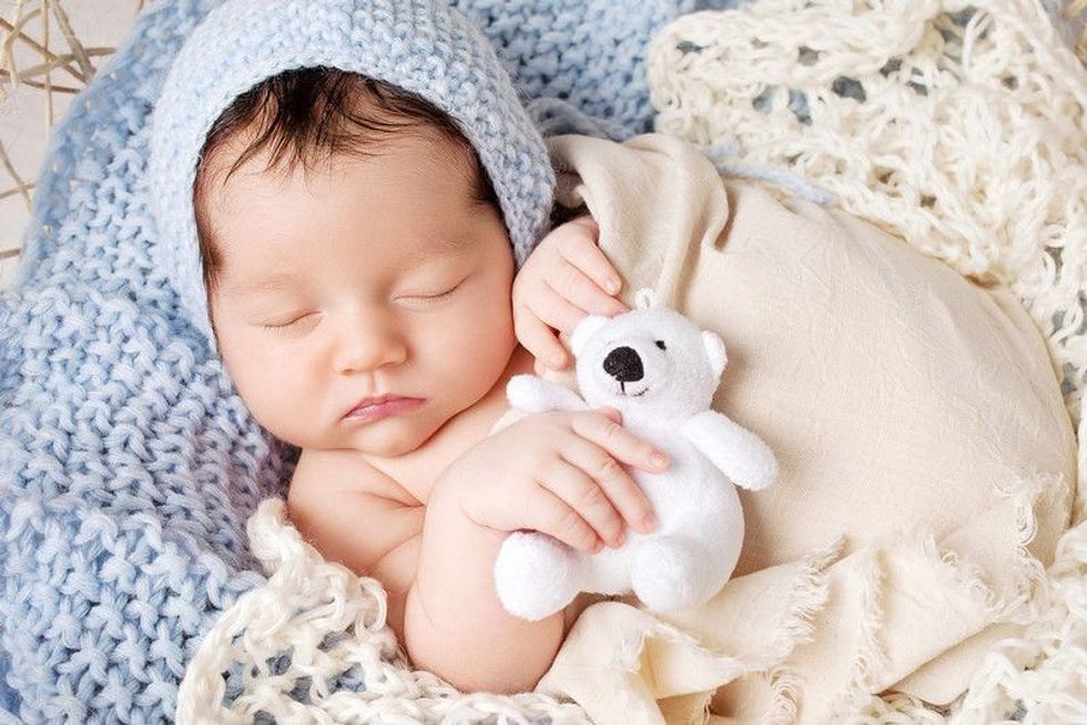 Sweet newborn baby sleeps in a basket.