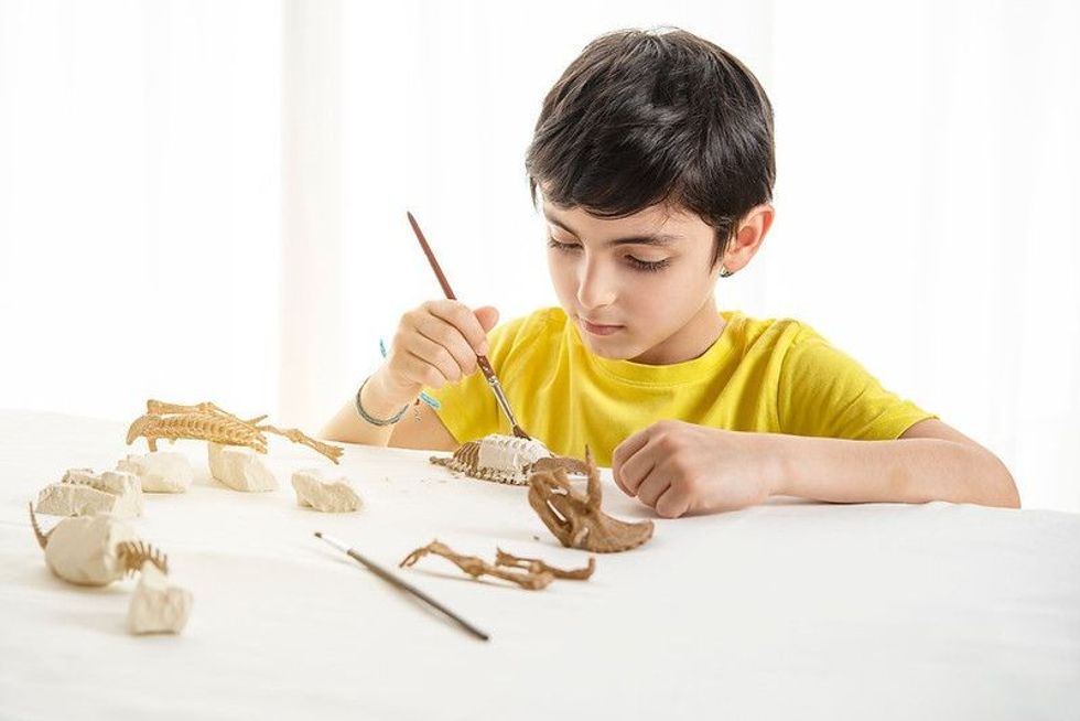 Young child plays as a paleontologist at home